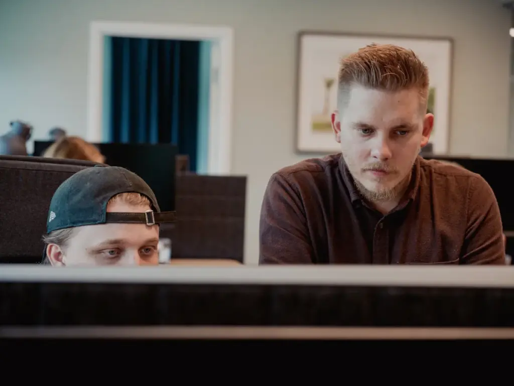 Chargenodes tekniska team samarbetar vid datorer för att utveckla smarta system för laddinfrastruktur.
